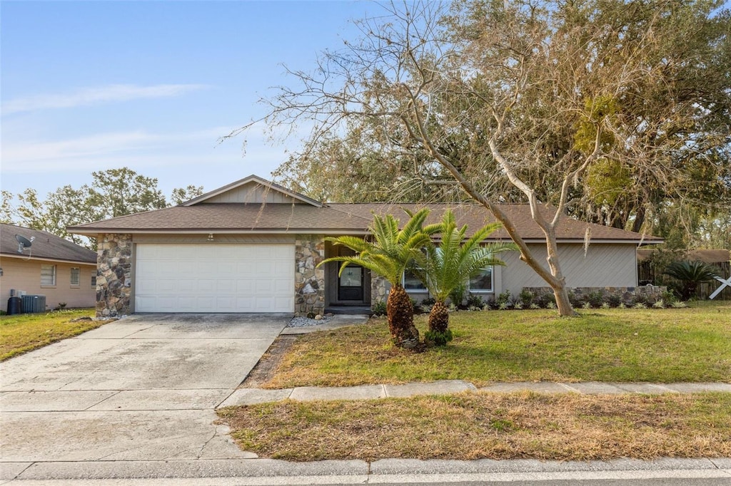 single story home with central AC, a garage, and a front yard