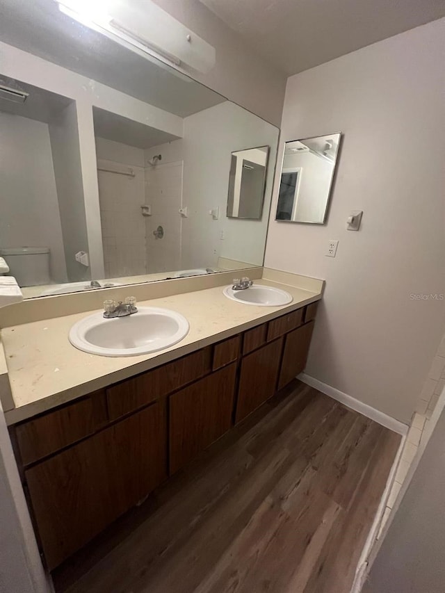 bathroom with vanity, toilet, walk in shower, and wood-type flooring