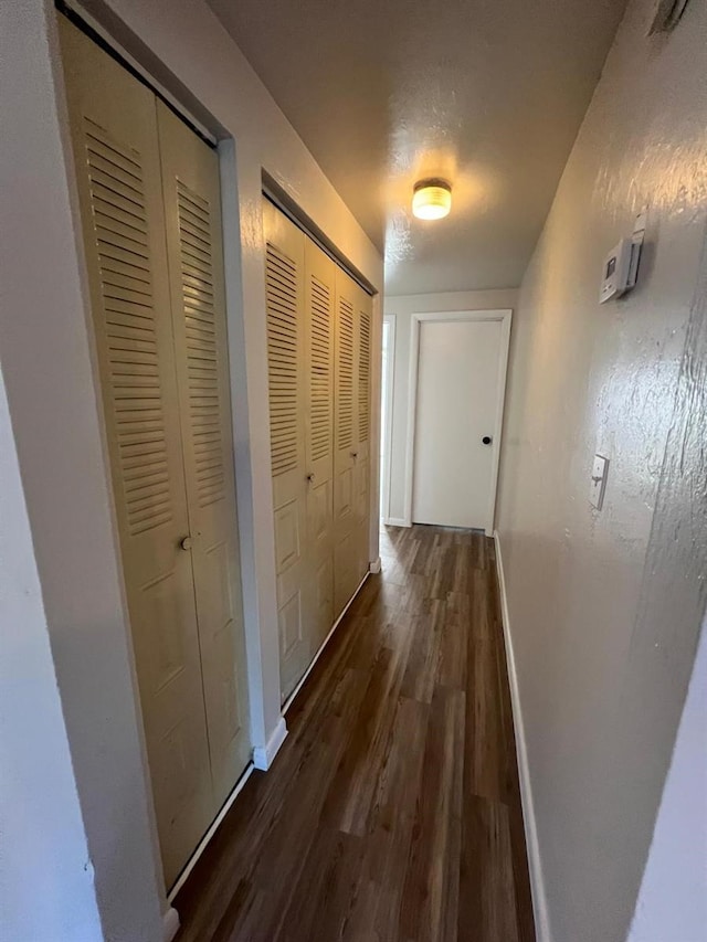 hall featuring a textured ceiling and dark hardwood / wood-style floors