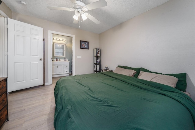 bedroom featuring a textured ceiling, light wood-type flooring, sink, ceiling fan, and connected bathroom