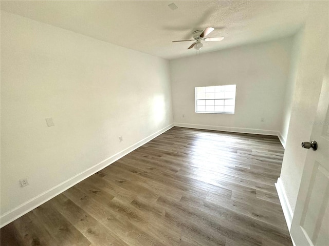 unfurnished room with ceiling fan, a textured ceiling, and dark hardwood / wood-style flooring