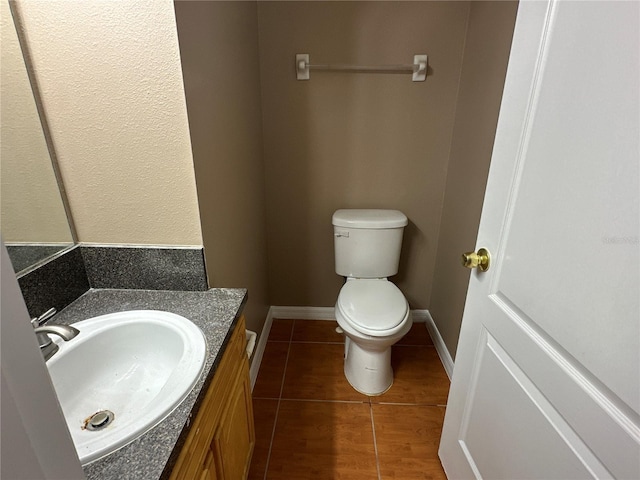 half bath featuring toilet, baseboards, wood finished floors, and vanity