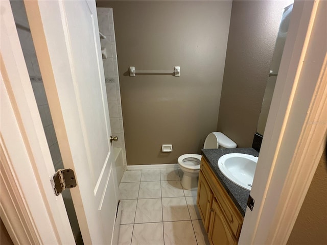 bathroom featuring baseboards, vanity, toilet, and tile patterned floors