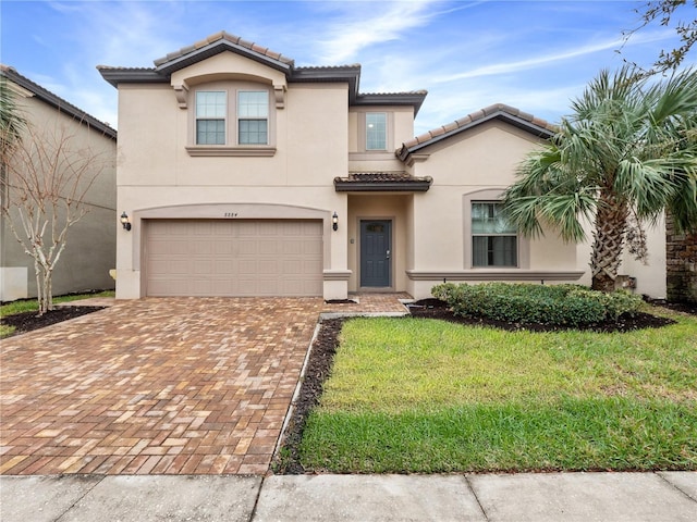 mediterranean / spanish-style home featuring a garage and a front lawn