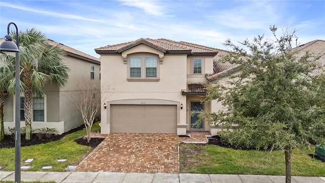 mediterranean / spanish-style house featuring a garage and a front lawn