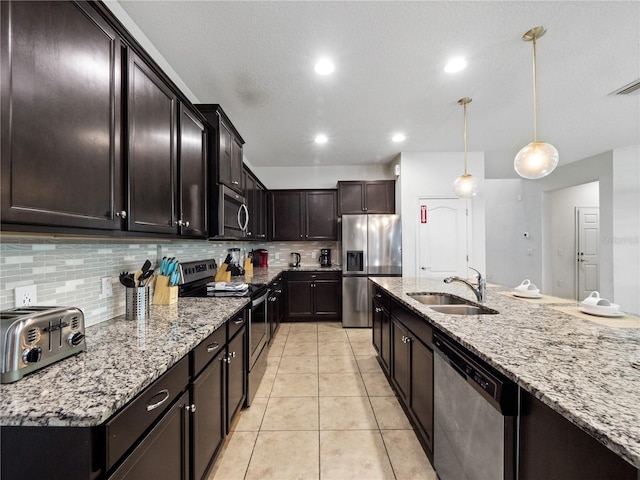 kitchen with appliances with stainless steel finishes, decorative light fixtures, sink, light tile patterned floors, and dark brown cabinets