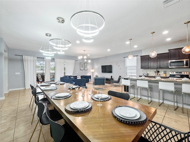 tiled dining room with a chandelier