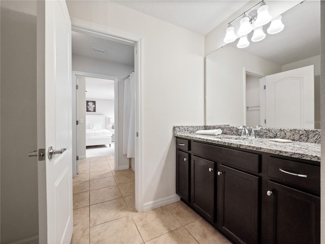 bathroom with tile patterned floors, vanity, and a textured ceiling