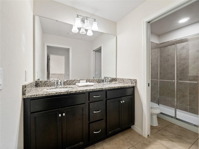 bathroom with tile patterned flooring, vanity, an enclosed shower, and toilet