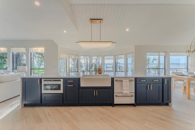 kitchen featuring sink, wood ceiling, pendant lighting, a healthy amount of sunlight, and oven