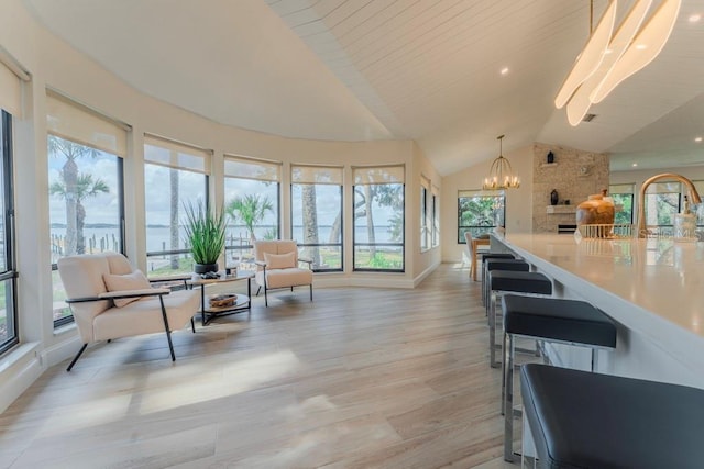 interior space featuring an inviting chandelier, a healthy amount of sunlight, and vaulted ceiling