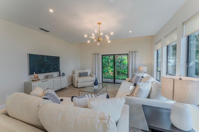 living room with a chandelier and light wood-type flooring