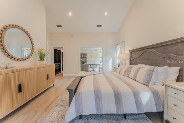 bedroom featuring lofted ceiling and light wood-type flooring