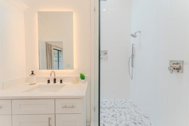 bathroom with vanity and a tile shower