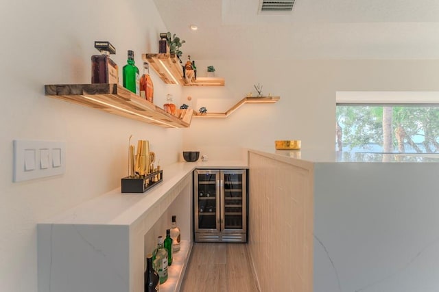 bar featuring hardwood / wood-style flooring and wine cooler