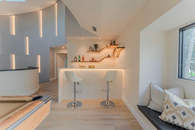 bar with light hardwood / wood-style flooring