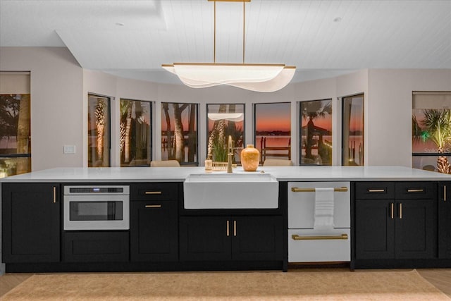 kitchen featuring oven, sink, and hanging light fixtures