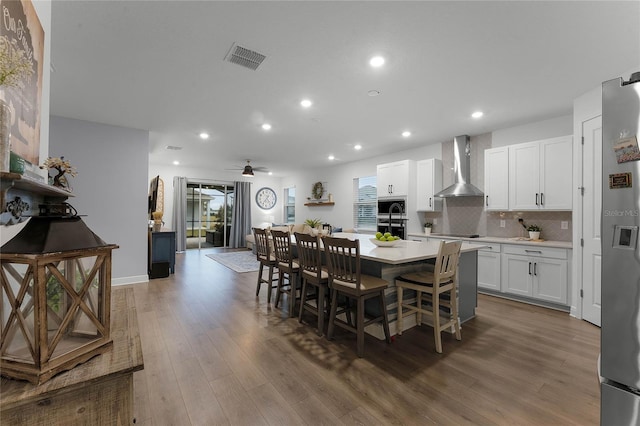 dining space featuring wood-type flooring and ceiling fan