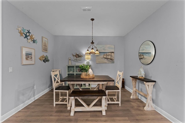 dining room with a notable chandelier and dark wood-type flooring