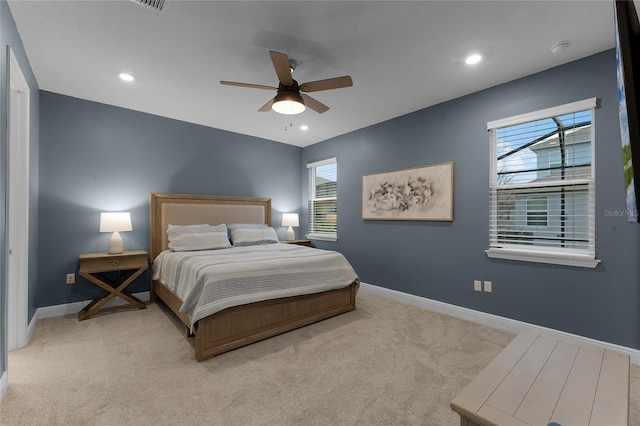 carpeted bedroom featuring multiple windows and ceiling fan