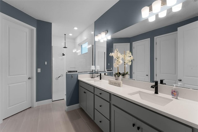 bathroom with a tile shower, vanity, and tile patterned floors