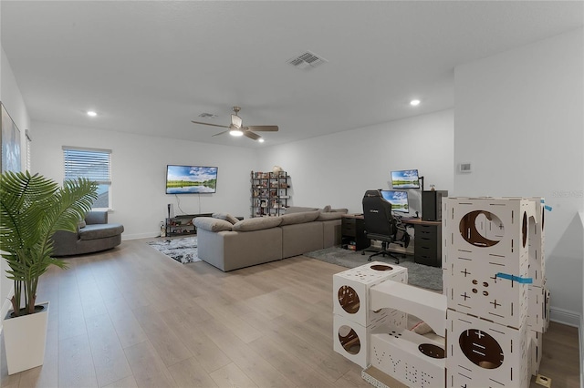 living room with ceiling fan and light wood-type flooring