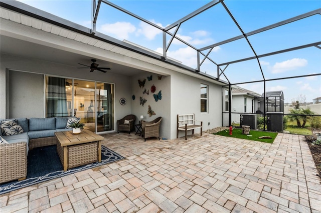 view of patio featuring outdoor lounge area, ceiling fan, and glass enclosure