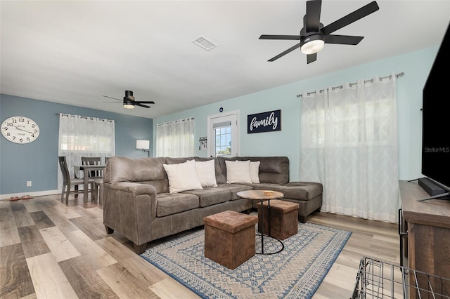 living room featuring ceiling fan and light hardwood / wood-style flooring