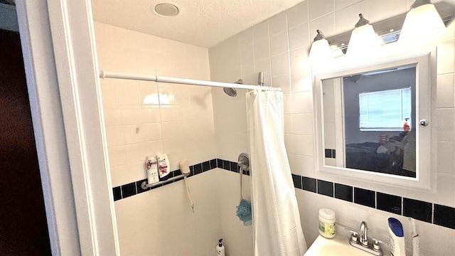 bathroom featuring tile walls, sink, backsplash, a textured ceiling, and shower / tub combo with curtain