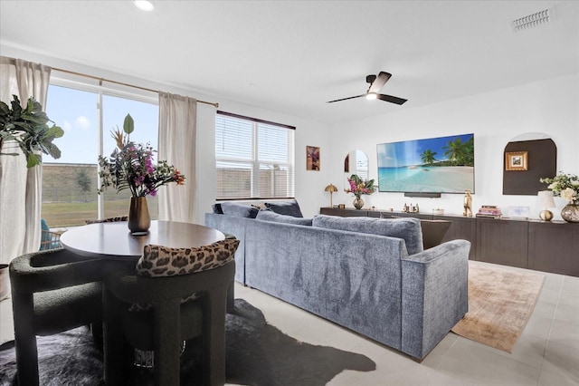 living area featuring a ceiling fan, visible vents, and light tile patterned floors