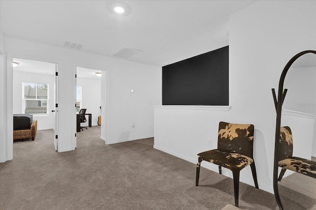 living area featuring carpet flooring and visible vents