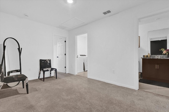 living area with attic access, light carpet, visible vents, and baseboards