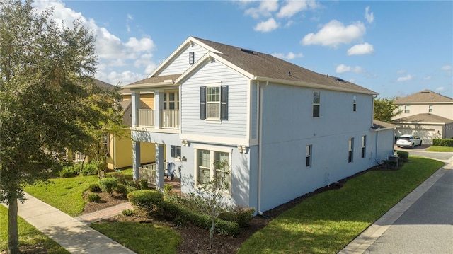 view of home's exterior with a yard and a balcony