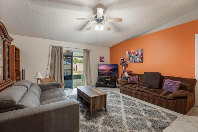 living room featuring light tile patterned flooring, lofted ceiling, ceiling fan, and a textured ceiling