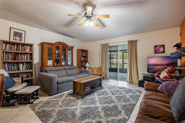 living room featuring light tile patterned flooring, ceiling fan, vaulted ceiling, and a textured ceiling