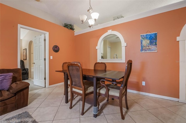 tiled dining area featuring ornamental molding, a chandelier, vaulted ceiling, and a textured ceiling