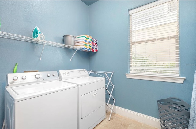 clothes washing area featuring laundry area, washer and clothes dryer, and baseboards