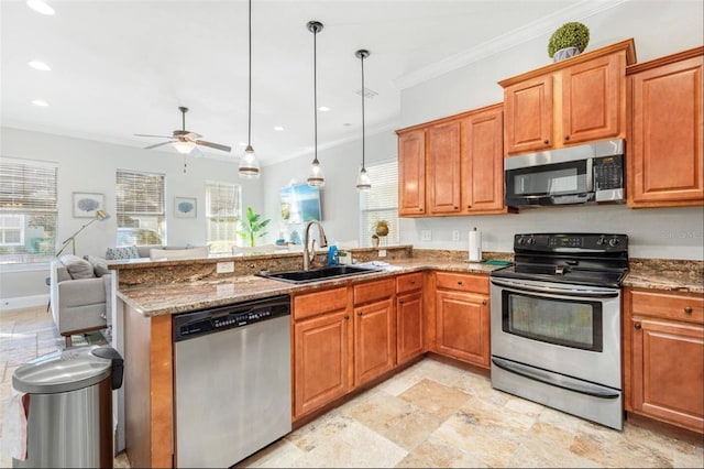 kitchen featuring a sink, hanging light fixtures, appliances with stainless steel finishes, brown cabinets, and crown molding