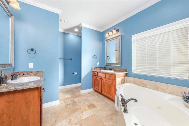 full bath featuring ornamental molding, two vanities, a sink, and a jetted tub