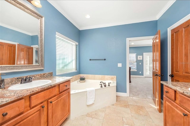 bathroom with a garden tub, crown molding, two vanities, and a sink