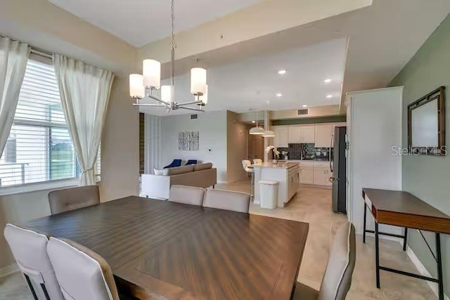 dining space featuring sink and a notable chandelier