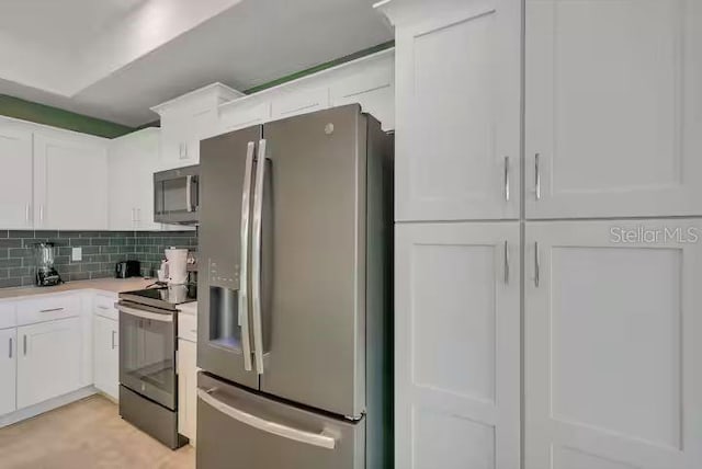 kitchen with white cabinets, appliances with stainless steel finishes, and tasteful backsplash