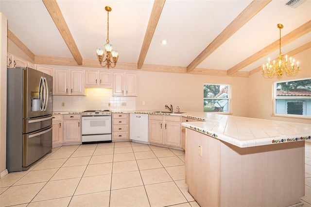 kitchen with sink, a chandelier, light tile patterned floors, kitchen peninsula, and white appliances