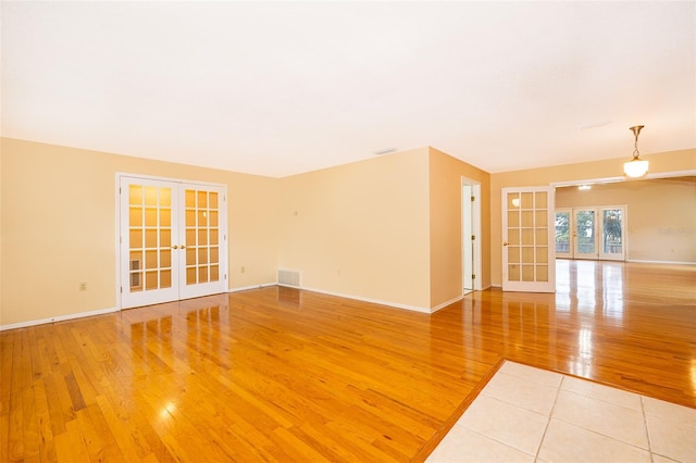 empty room featuring light hardwood / wood-style floors and french doors