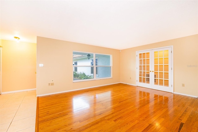 unfurnished room featuring french doors and light wood-type flooring