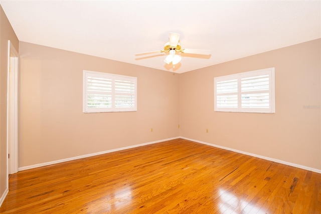 spare room with ceiling fan, plenty of natural light, and hardwood / wood-style floors