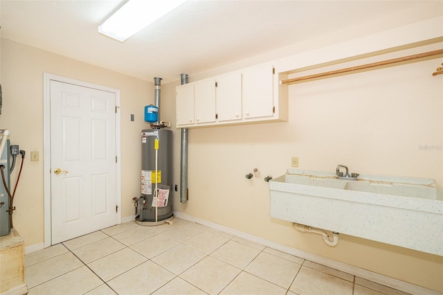 laundry room featuring washer hookup, gas water heater, cabinets, and light tile patterned flooring