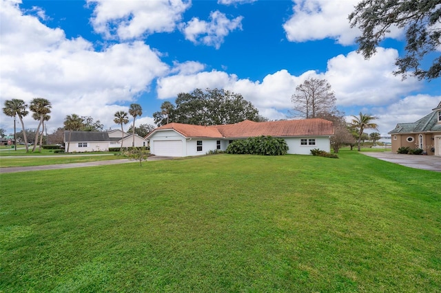 ranch-style house with a garage and a front lawn