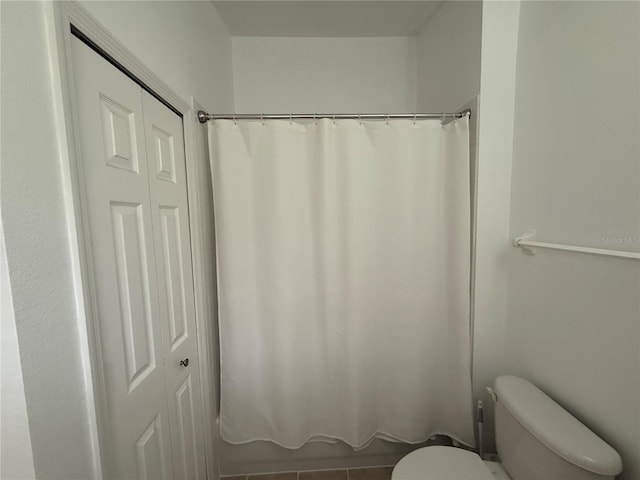 bathroom with shower / bathtub combination with curtain and toilet