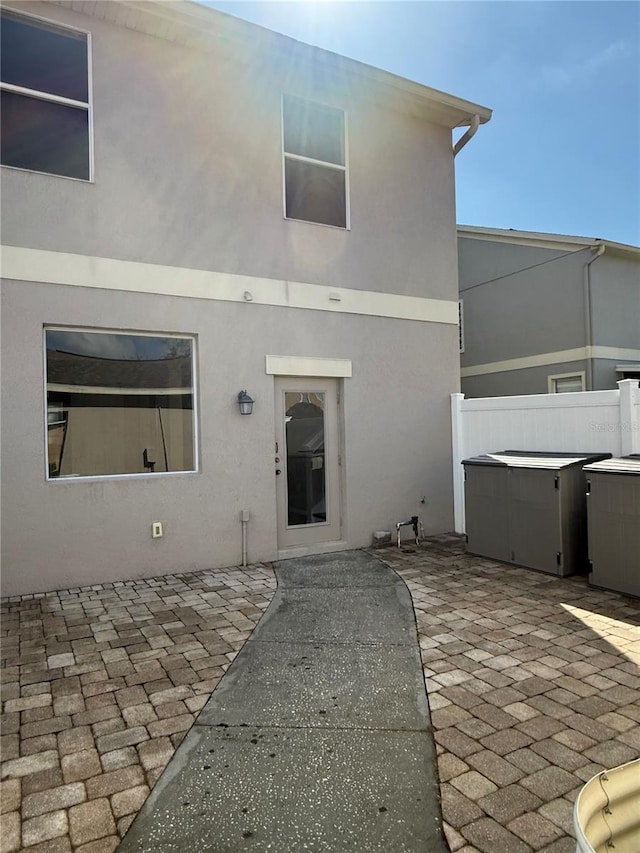 rear view of house with a jacuzzi and a patio